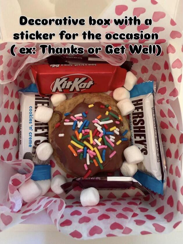 A decorated gift box with a cookie and candy