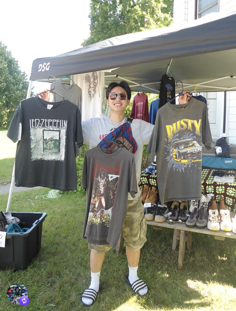 Two Cool Vintage holding up vintage racing and rock tees at a pop up tent